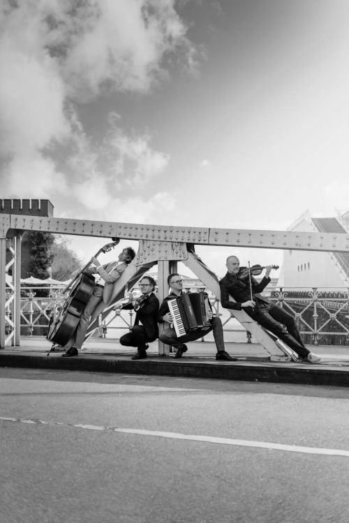 Foto des Quartetts Uwaga! mit ihren Instrumenten auf einer Brücke